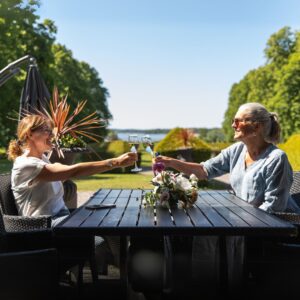 två kvinnor som skålar med champagneglas ute på slottsterrassen